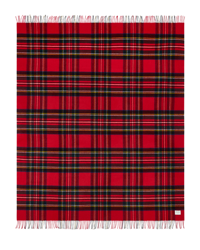 Flatlay image of a wool blanket folded into a small rectangle, the edge of the blanket is fringed, the blanket is multi-coloured check with alternating shades of navy and forest green. Image of the blanket laid out flat with fringing on both edges.