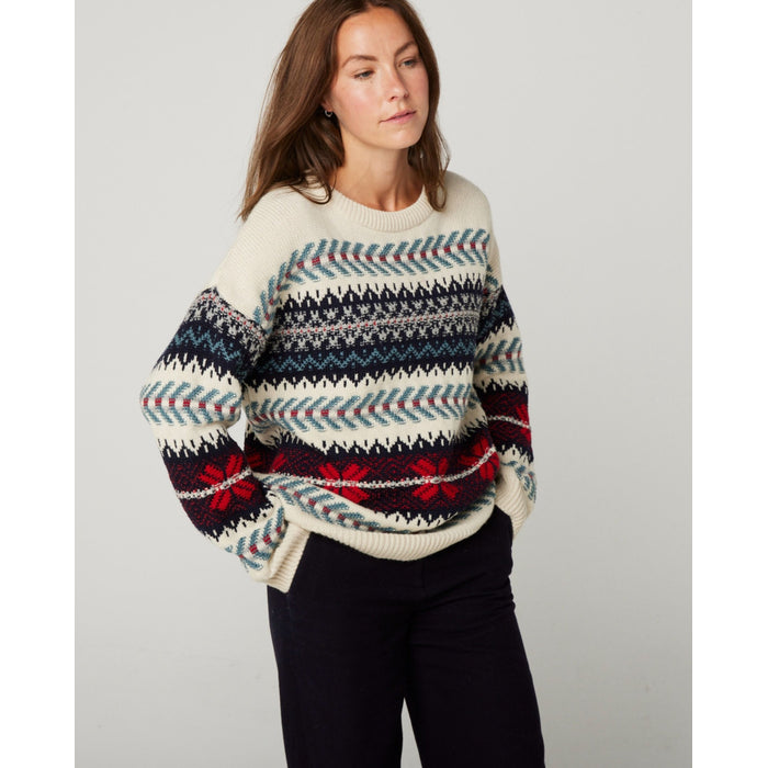 Flatlay image of a knitted cream jumper with horizontal nordic knitted patterns in blue and red going down the jumper.
