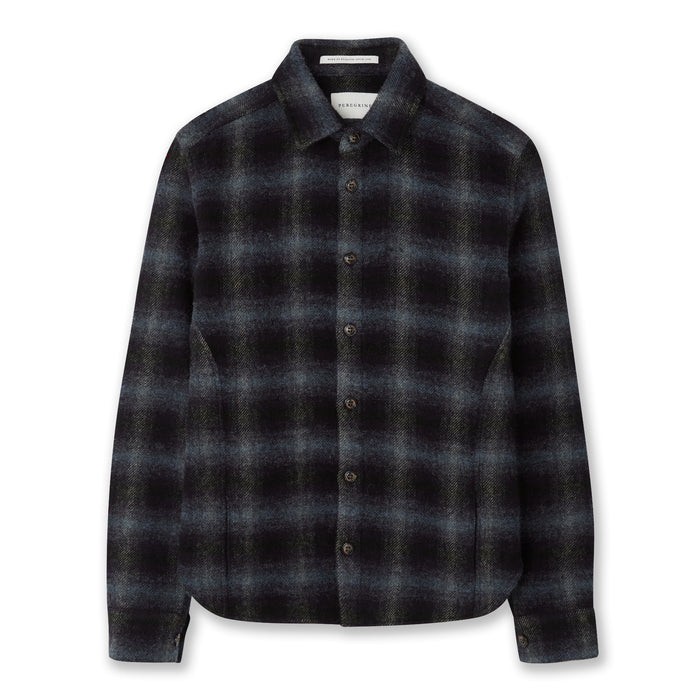 Flatlay image of a navy checked wool shirt with seven buttons down the center front fastening the collared shirt closed, the shirt has a slightly curved hem, the main base colour of the shirt is navy with the check pattern being a lighter shade of grey/blue.